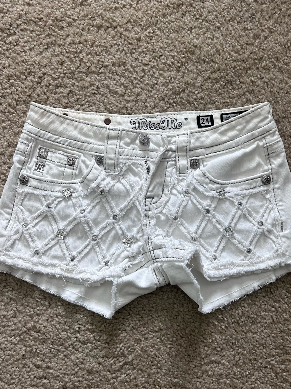 White Miss Me shorts with diamond-shaped stitching and silver studs